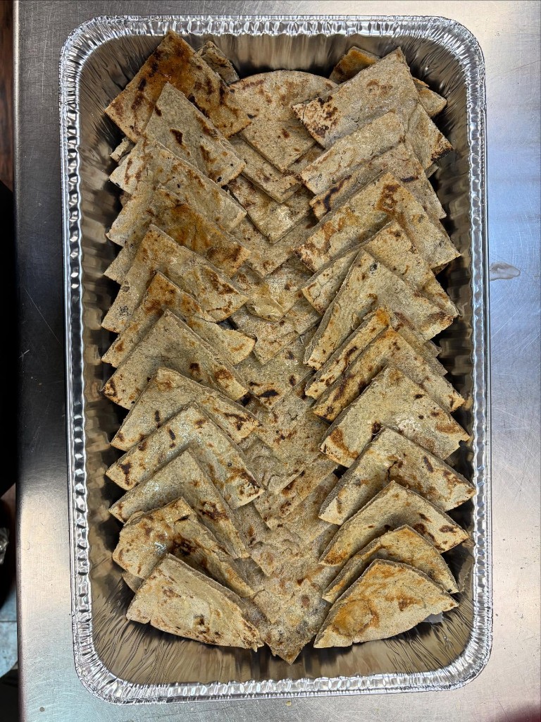 Fresh hand-pressed rotla flatbreads ready for catering