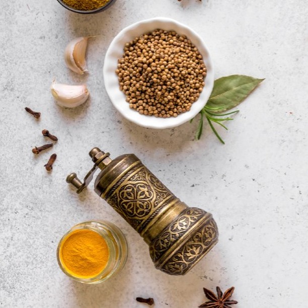 Fresh Indian spices - turmeric, coriander seeds, bay leaves, and cloves