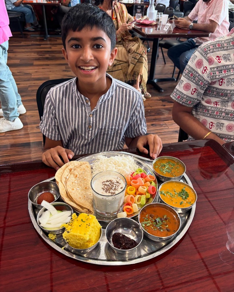 Guest enjoying a complete Vishala thali with assorted curries and breads